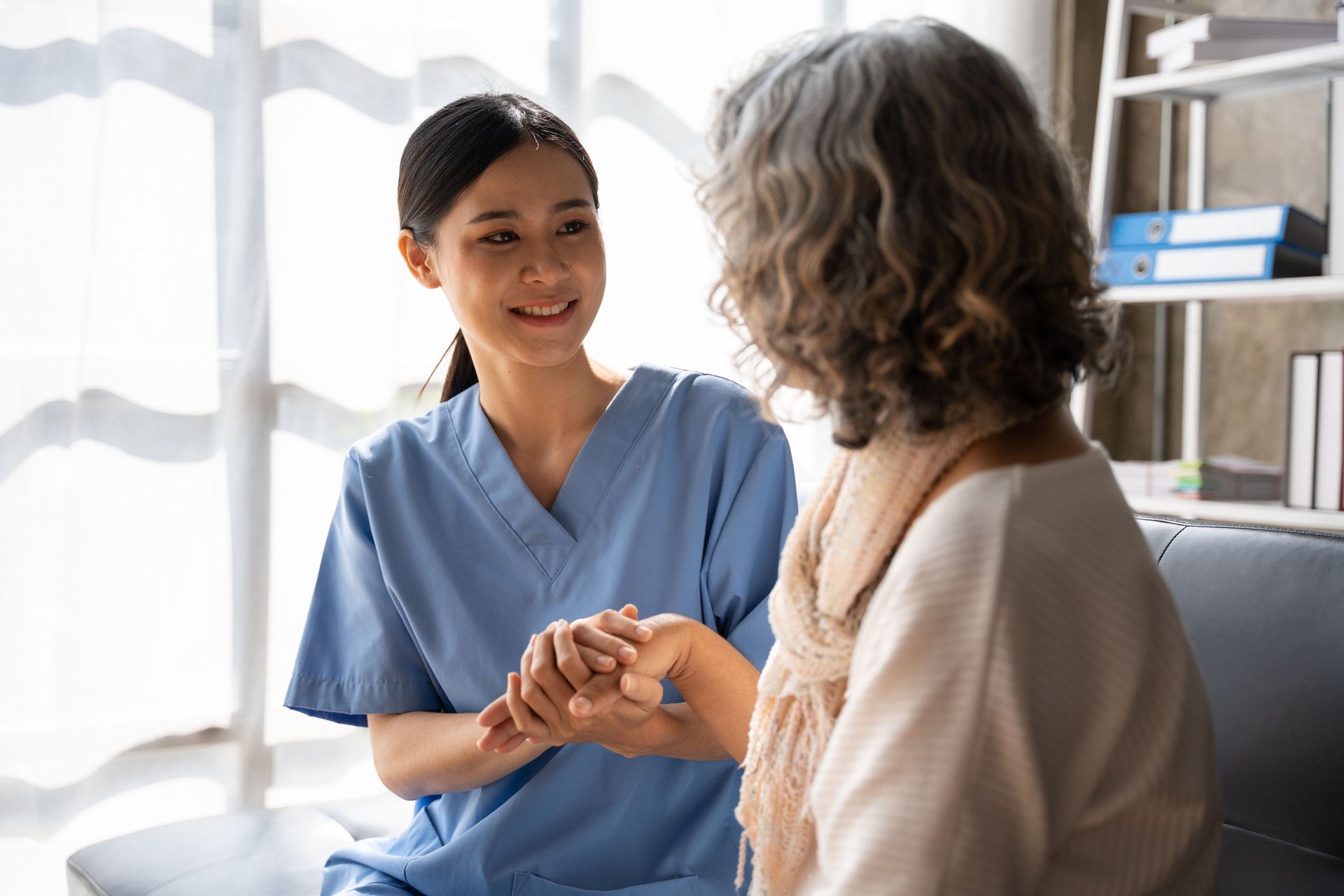 Asian young nurse supporting elderly patient disabled woman in hospital. Elderly patient care concept.